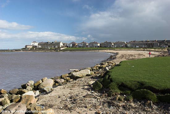 View of the small beach in Amble beside the harbour.