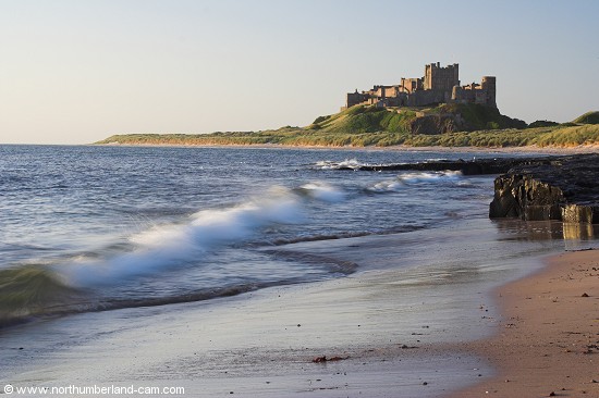 Early summer morning view of Bamburgh Beach and Castle.